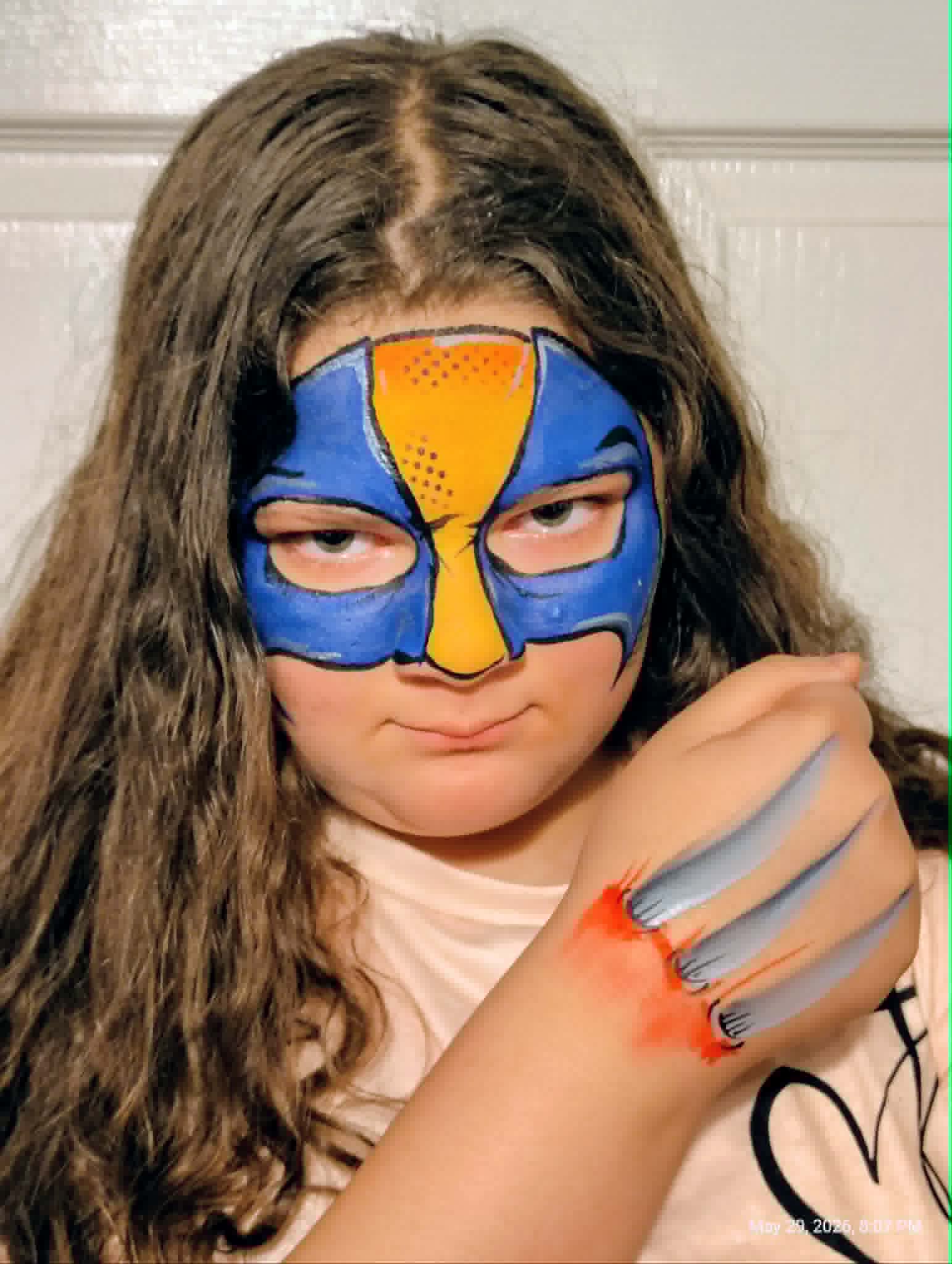 Girl with a blue and orange superhero half-face mask design