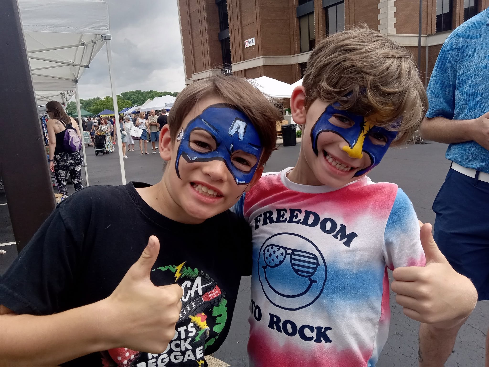 Two boys with superhero face painting masks at a party