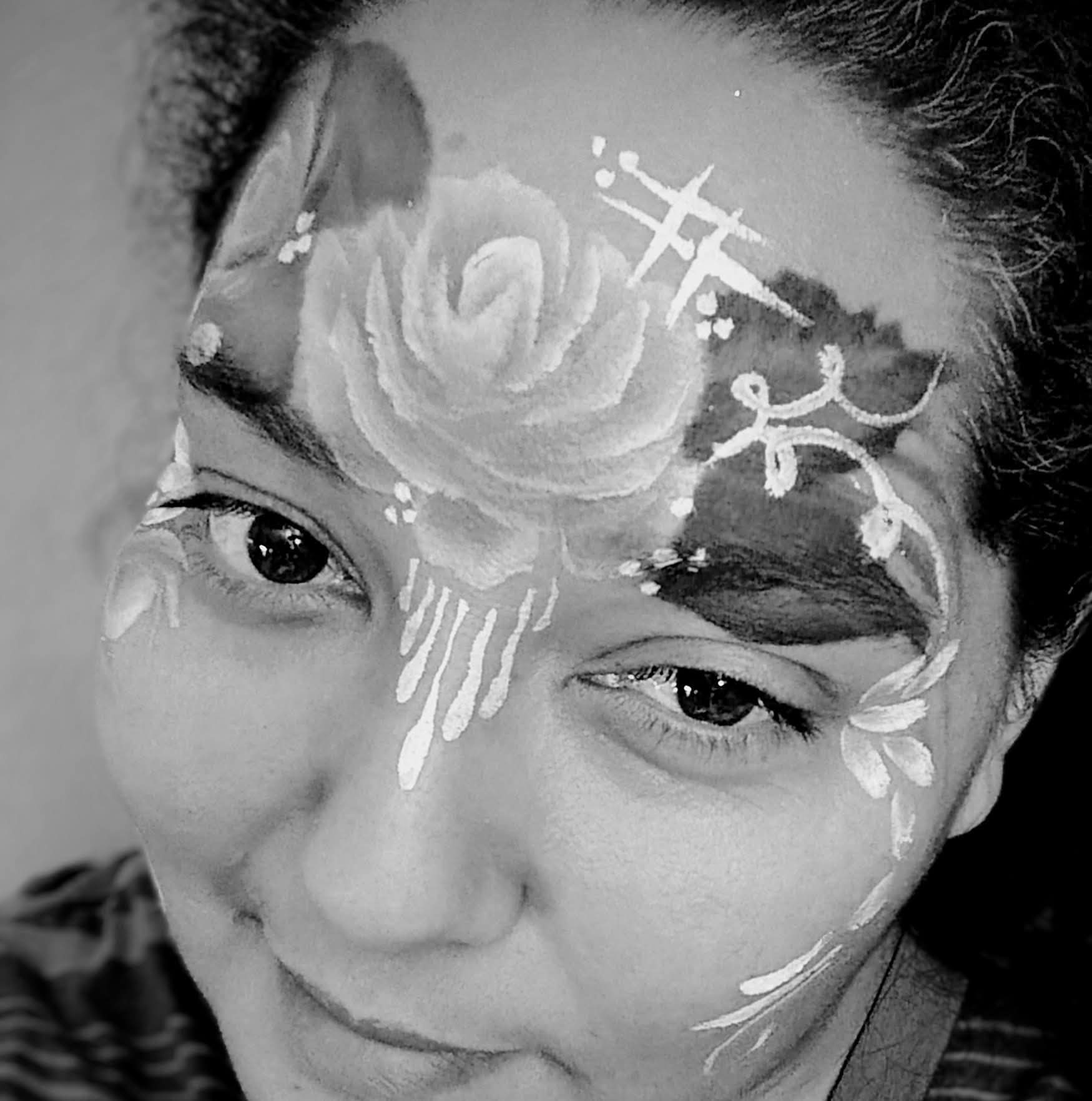 Sandra with a rose face painting design at an event